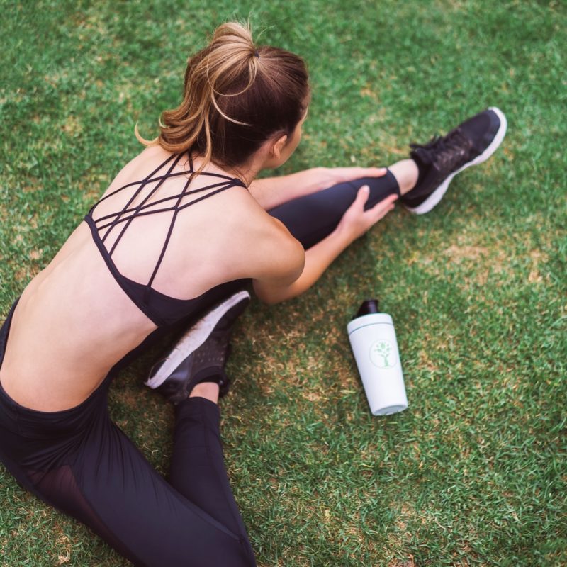 woman in black lingerie holding white bottle